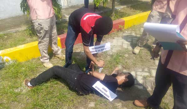 SADIS: Tersangka Bayu (20) saat memeragakan adegan penusukan terhadap tubuh korban. (Korban diperagakan model). foto: eky nurhadi/ BANGSAONLINE