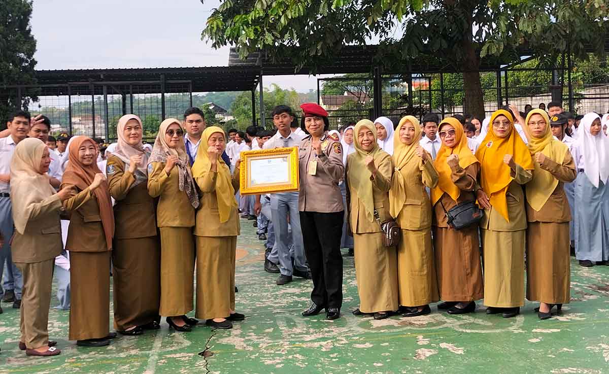 Kepala BNN Kota Batu, AKBP Renny Puspita, saat menyerahkan piagam penghargaan yang diterima Wakil Kepala Sekolah bidang Kesiswaan SMAN 2 Batu, Sri Sondari.