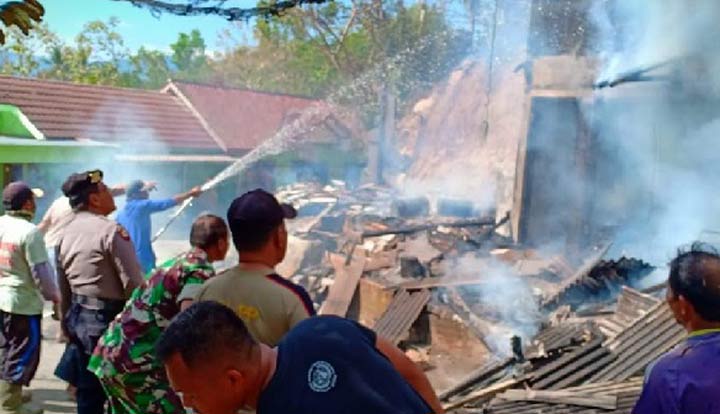 Petugas damkar melakukan pemadaman terhadap bangunan warung yang diamuk si jago merah.