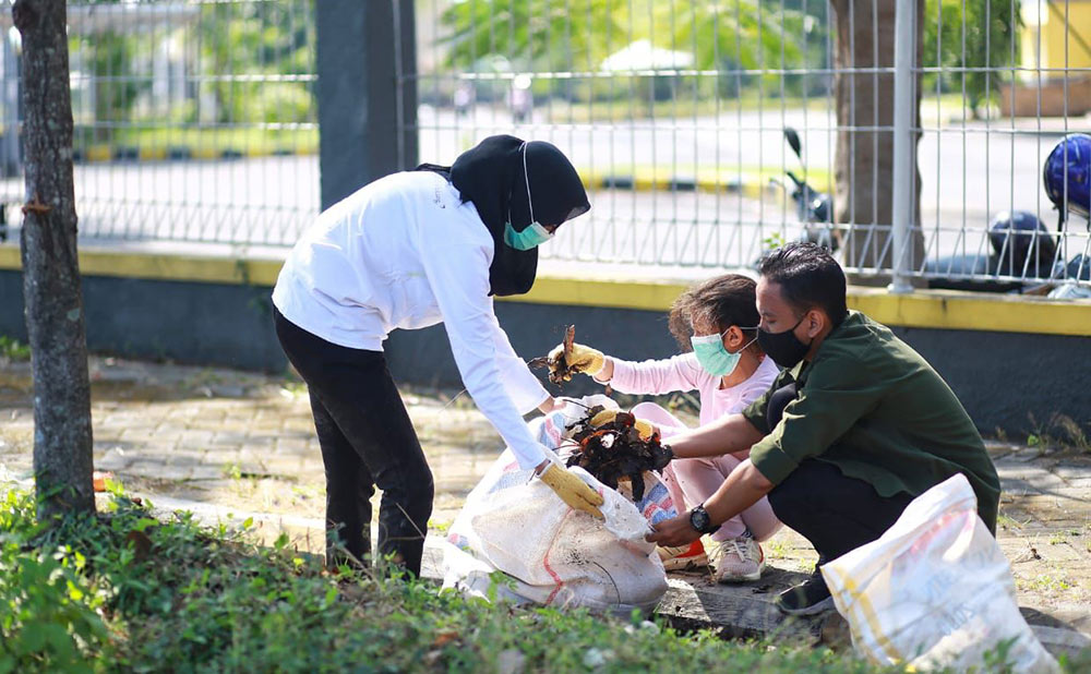 Ketua TP PKK Kota Kediri Ferry Silviana Abdullah Abu Bakar dan putri pertamanya saat ikut bersih-bersih sampah di kawasan GOR Jayabaya, Kota Kediri. (foto: Ist).