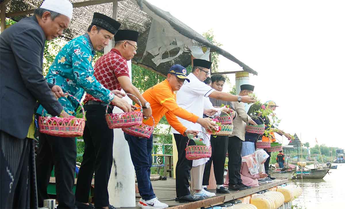 Pj Wali Kota Mojokerto saat menaburkan bunga di Sungai Tlocor sebagai ungkapan bela sungkawa.