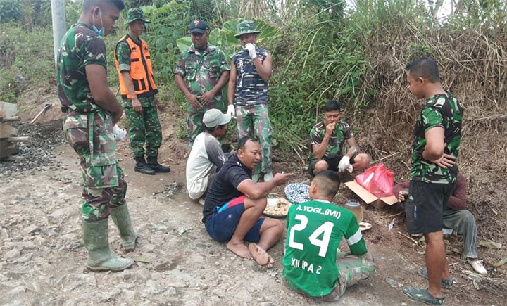 Satgas TMMD bersama masyarakat saat istirahat usai penggarapan jalan.