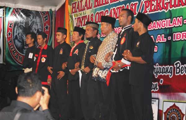 Para sesepuh dan pimpinan pencak silat dari berbagai perguruan bergandeng tangan sebagai simbol menciptakan kerukunan. (suwandi/BANGSAONLINE)