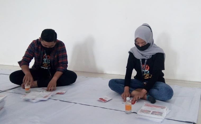Petugas pelipatan surat suara saat melakukan tugasnya.