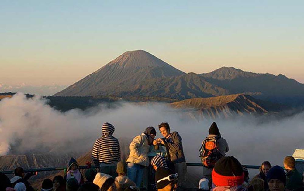 Pengunjung berswafoto dengan latar berlakang Gunung Bromo dan Gunung Semeru.