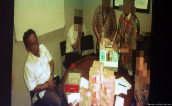 Fuad Amin setelah ditangkap KPK. Tampak ia bersama uang ratusan juta sebagai barang bukti. Foto: okezone