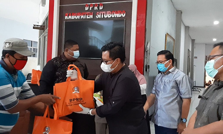 Ketua DPRD Kabupaten Situbondo Edi Wahyudy saat membagikan paket sembako kepada para PKL yang terdampak PPKM Darurat Covid-19. (foto: MURSIDI/BANGSAONLINE)