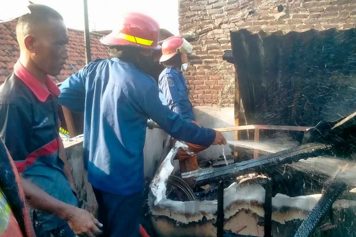 Damkar Pos Waru saat melakukan pembasahan di rumah warga Wedoro Candi gang Gedongan II, Waru, Sidoarjo.