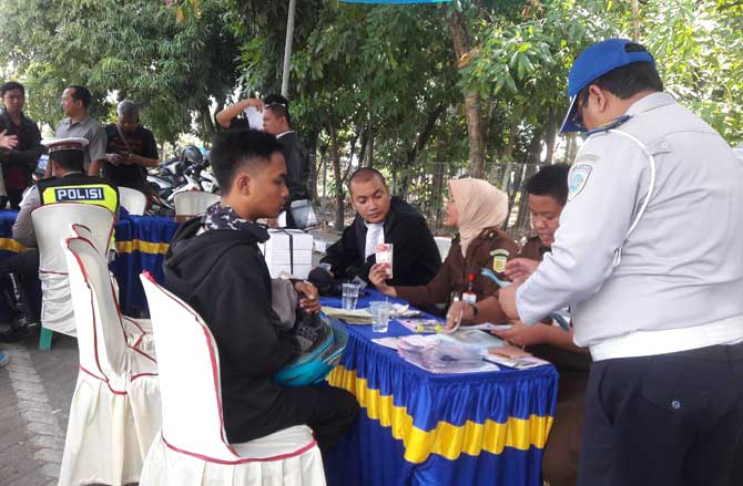 Petugas ketika menilang dan menyidang para pelanggar lalu lintas yang terkena razia. foto: SYUHUD/ BANGSAONLINE