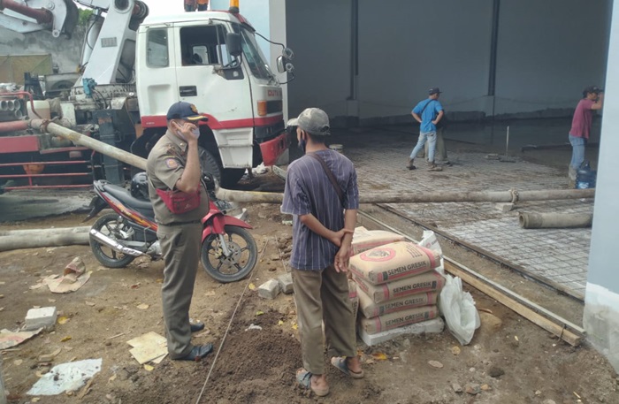 Petugas Satpol PP Kota Pasuruan saat menghentikan paksa pembangunan sebuah gedung.