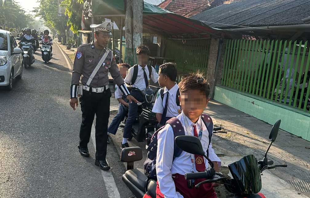 Petugas Polres Pamekasan saat memberikan teguran kepada anak-anak yang menggunakan sepeda listrik di jalan raya.