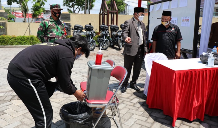 Pj. Bupati Hudiyono melihat simulasi penerapan prokes di TPS di Mapolresta Sidoarjo, Sabtu (5/12). foto: istimewa
