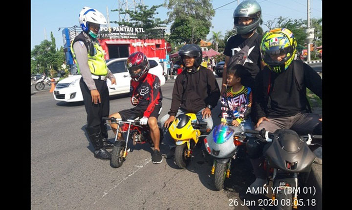 Petugas sedang menghentikan 4 pengendara motor mini.