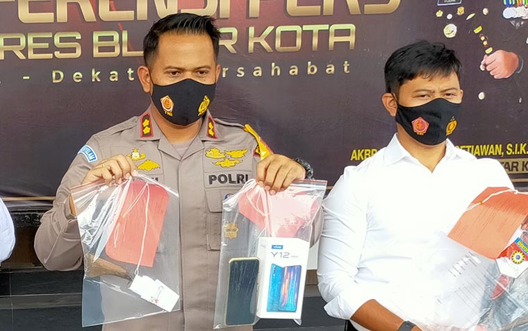 Kapolres Blitar Kota AKBP Yudhi Hery Setyawan saat menunjukkan Hp milik korban dan sajam yang digunakan tersangka.