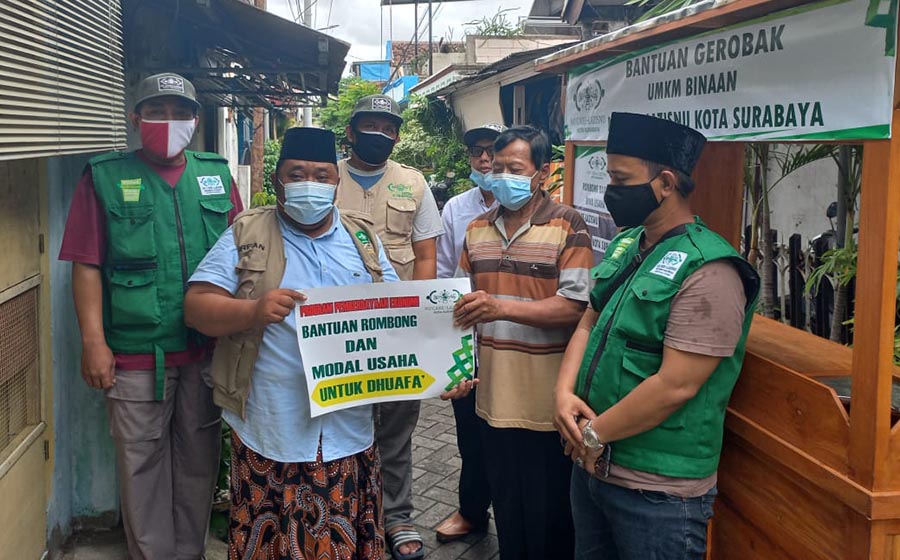 Ketua NU Care - LAZISNU Kota Surabaya, Yusub Hidayat (dua dari kanan) saat menyalurkan bantuan rombong dan modal usaha kepada Irnadi, pedagang bakso. foto: ist.