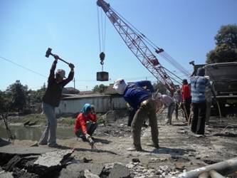 ?

Pekerja proyek tengah menggempur Jembatan Tulangan dengan cara manual. foto:daryanto/BANGSAONLINE