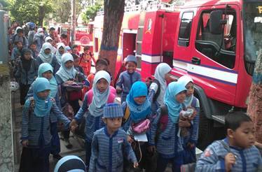 PANIK. Ratusan siswa-siswi berhamburan keluar gedung SD Muhammadiyah, Bojonegoro. Siswa ketakutan karena gardu induk listrik di ruang guru terbakar. Foto: Eky Nurhadi/BANGSAONLINE