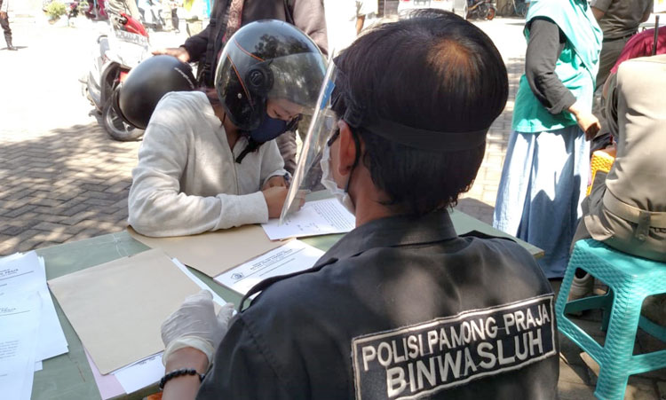 Salah satu pengendara yang melanggar aturan PSBB ditindak oleh petugas.