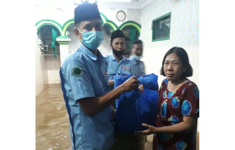 Para pengurus Badan Komunikasi Pemuda Remaja Masjid Indonesia (BKPRMI) saat menyalurkan bantuan sembako kepada korban banjir di tanah rendah kampung melayu Jakarta Timur, Minggu (21/2/2021). foto: ist.