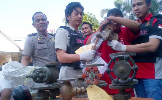 Sumiran (dua dari kanan), menunjukkan barang bukti berupa kran besi yang dicurinya. (foto: rusmiyanto/BANGSAONLINE)