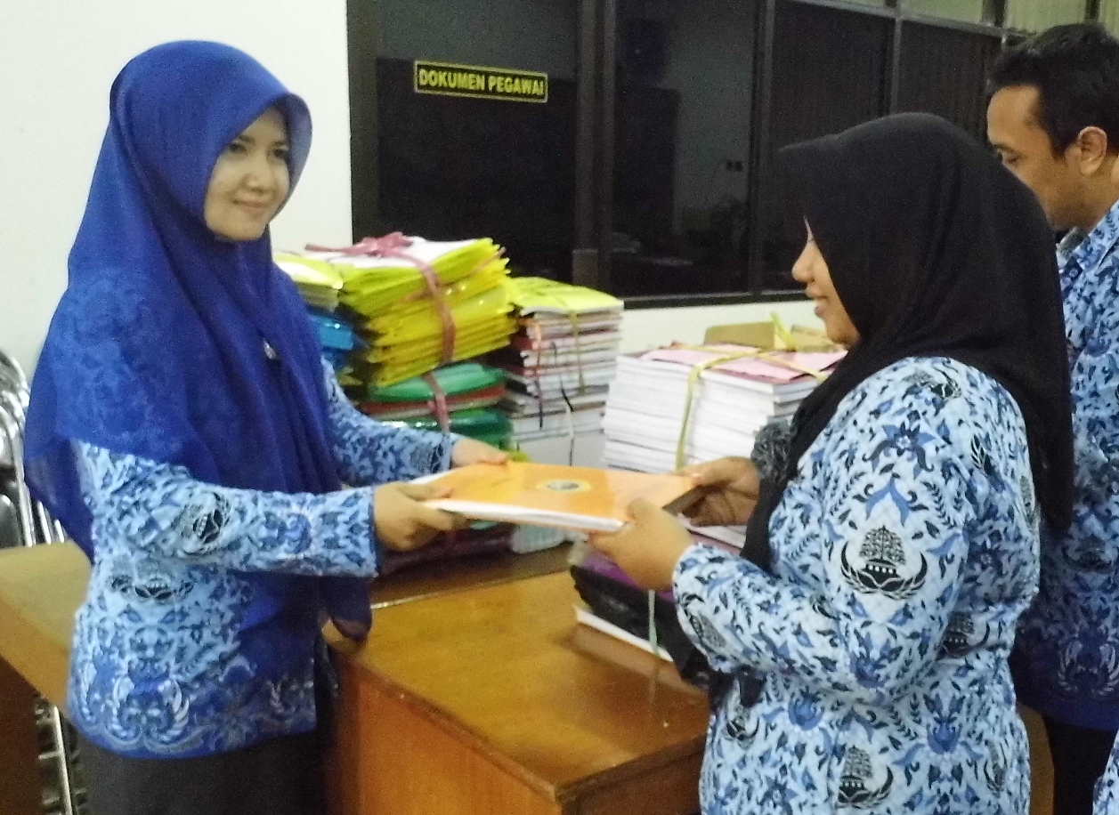 SETOR - Seorang PNS Gresik menyetorkankopian skripsi miliknya,  Selasa (18/11/2014). foto : syuhud/BangsaOnline
