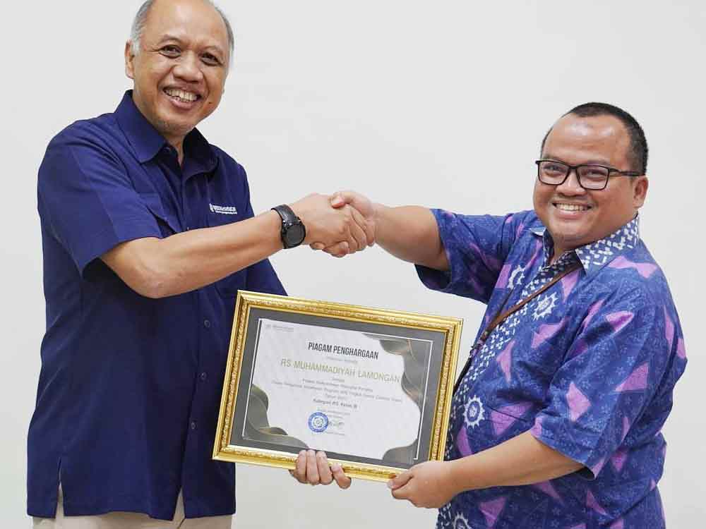 Kepala BPJS Kesehatan Cabang Gresik, Janoe Tegoeh Prasetijo menyerahkan piagam penghargaan kepada Direktur Rumah Sakit Muhammadiyah Lamongan. (Ist)
