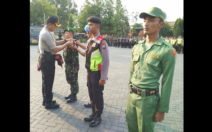 Kapolres Pasuruan AKBP Raydian Kokrosono saat menyematkan tanda dimulainya operasi sekaligus pengamanan Pileg dan Pilpres mendatang. Foto: ANDY F/BANGSAONLINE