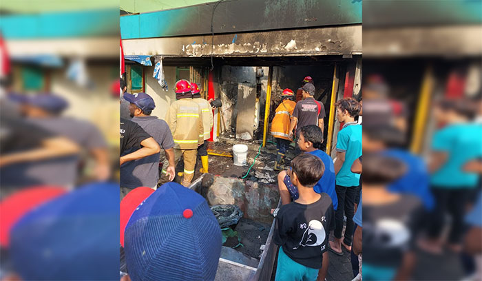 Petugas saat melakukan pendinginan pom mini di Waru, Sidoarjo, yang terbakar.