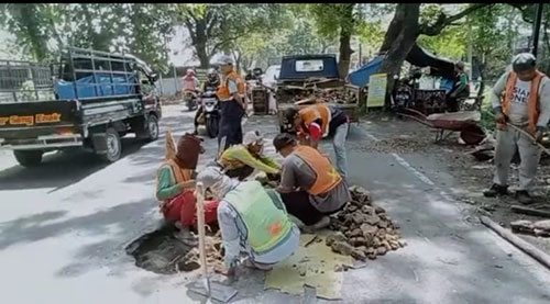 Petugas dari Dinas PU Bina Marga dan Bina Kontruksi Kabupaten Pasuruan saat membenahi jalan berlubang.