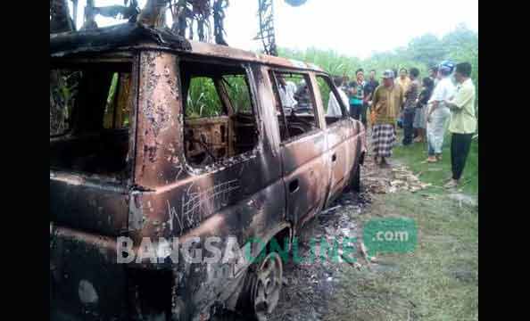 Kondisi mobil yang diduga milik maling hewan setelah dibakar warga. foto: ROMZA/ BANGSAONLINE