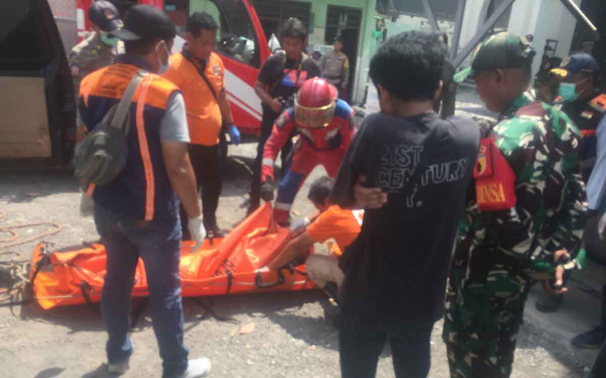 Petugas saat mengevakuasi jenazah yang membusuk di Karangpilang, Surabaya.
