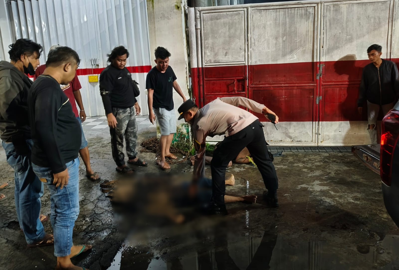Petugas Polres Gresik saat olah TKP dan evakuasi  kedua terduga pelaku yang tergeletak di tanah usai dimassa. foto: ist.
