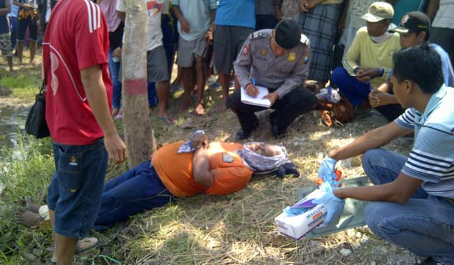 PENASARAN: Puluhan warga sekitar mengerumuni jasad korban saat petugas Polsek Kanor mendata ciri-ciri korban. foto: eky nurhadi/ BANGSAONLINE