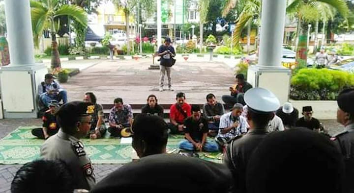 Aksi sejumlah aktivis saat menggelar tahlil dan membaca surat yasin di depan gedung DPRD Jember.
