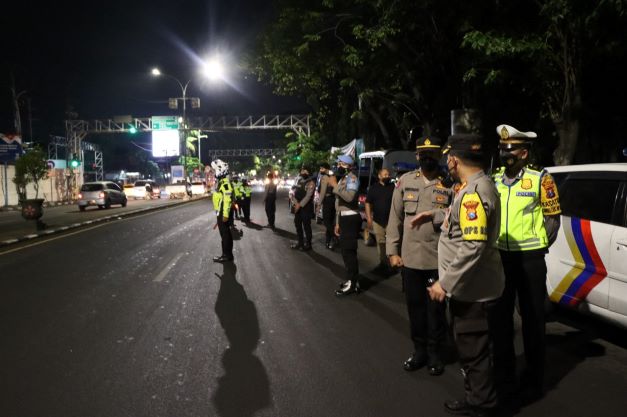 Petugas Polres Gresik saat melakukan penyekatan untuk mencegah penularan PMK hewan ternak sapi. Foto: SYUHUD/BANGSAINLINE.