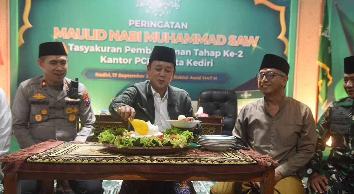 Ketua PCNU Kota Kediri, KH. Abu Bakar Abdul Jalil, saat memotong tumpeng yang selanjutnya diberikan kepada Gus Qowim. Foto: Ist