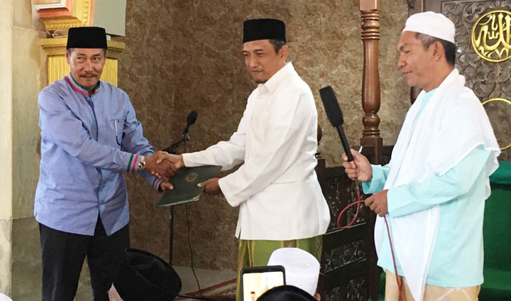 Djoko Susanto saat menyerahkan sertifikat masjid Al-Ikhlas kepada takmir masjid.
