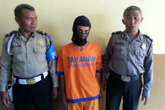Tersangka aksi perampasan, Aji, diapit dua petugas Polsek Krian.