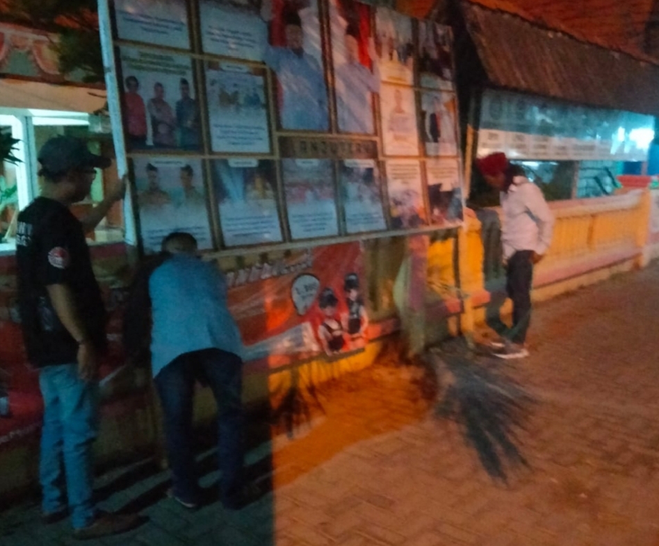 Petugas Bawaslu Gresik saat menurunkan APK pasangan Yani-Alif yang dipasang di depan Balai Desa Sukowati, Kecamatan Bungah. Foto: Ist.