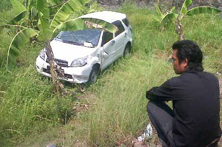 MASUK SAWAH. Mobil Daihatsu Terios yang masuk ke sawah karena menghindari pengendara motor yang nyelonong menyeberang, kemarin. foto: khumaidi/BANGSAONLINE