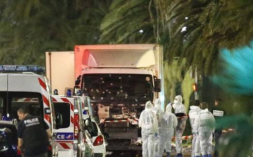 Polisi dan petugas forensik Perancis memeriksa truk yang menabrak kerumunan massa pada perayaan Hari Bastille di kota Nice, Perancis Kamis malam (14/7). 