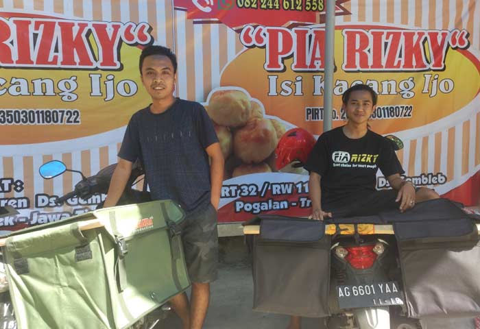 Rizky Fajar (kiri) dan keponakannya Andika Restu saat menjajakan Pia produksinya. foto: HERMAN/ BANGSAONLINE