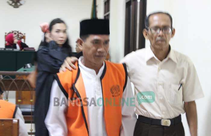 Kasnam (memakai rompi tahanan), Guru Cabul usai mengikuti sidang vonis di PN Jombang, Kamis (15/12). foto: ROMZA/ BANGSAONLINE