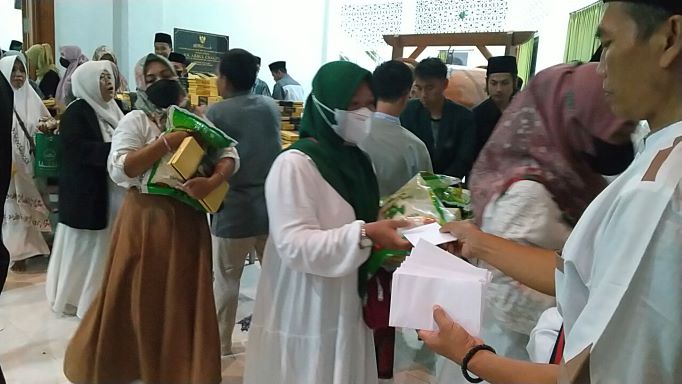 Para ibu-ibu saat menerima bingkisan berupa beras 5 kg, sarung dan uang Rp 100.000 di Masjid Kampus IKHAC Pacet Mojokerto Jawa Timur, Selasa (5/4/2022) malam. foto: MMA/ BANGSAONLINE