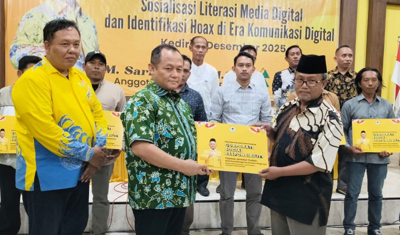 M. Sarmuji, Anggota Komisi VI DPR RI didampingi Ketua DPD Partai Golkar Kabupaten Kediri M. Hadi Setiawan (kiri) saat menyerahkan secara simbolis bantuan kepada salah seorang kader Golkar. Foto: Muji Harjita/BANGSAONLINE