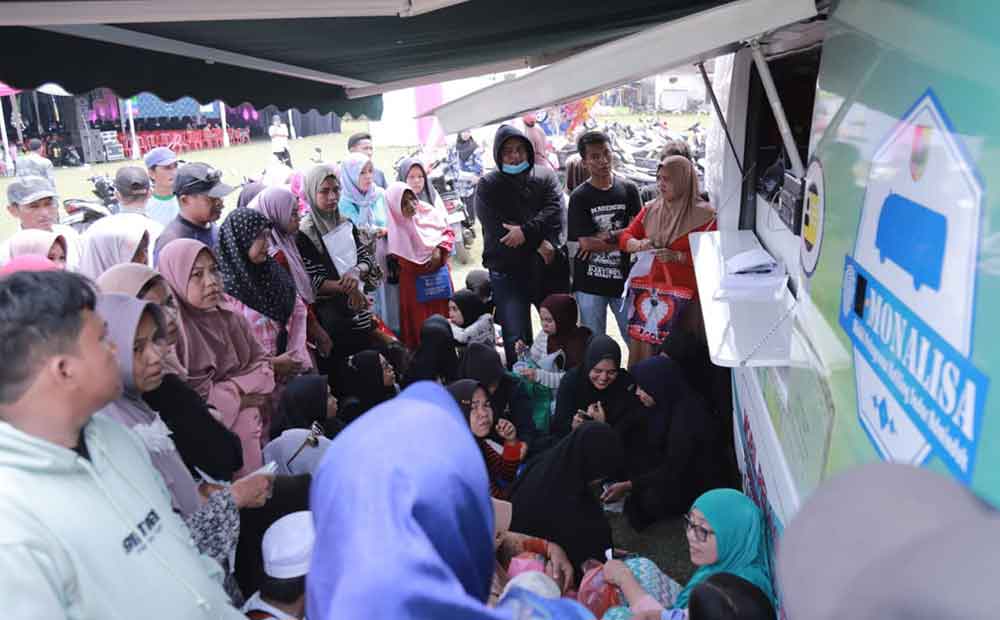 Warga antre mengurus adminduk melalui Mobil Monalisa Dispendukcapil Jember yang parkir di Lapangan Yosorati saat program Bunga Desaku.