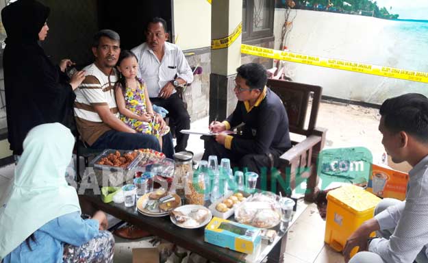 Khamsun (memangku anaknya), didampingi istri ketika dimintai keterangan petugas tim Labfor Polda Jatim. foto: SYUHUD/ BANGSAONLINE