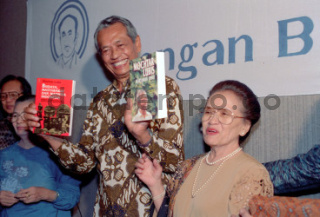 Mochtar Lubis didampingi istrinya, Nyonya Moen, memperlihatkan buku tentang dirinya saat merayakan hari ulang tahun yang ke-70 di Jakarta, 1992. Foto: Koleksi TEMPO/ Donny Metri; 08D/437/1992.