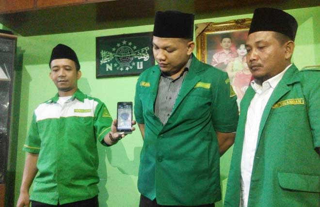 TUNJUKKAN BUKTI: Wakil Ketua didampingi Sekretaris GP Ansor Sidoarjo menunjukkan foto sebongkah batu yang ditemukan di rumah Ketua Ranting NU Kedungsolo, di Kantor GP Ansor Sidoarjo, Senin (26/9). foto: MUSTAIN/ BANGSAONLINE
