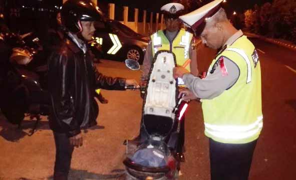 RAZIA: Petugas sedang memeriksa kendaraan yang melintas di JLT dalam razia yang digelar Kring Serse. foto: catur andy erlambang/BANGSAONLINE